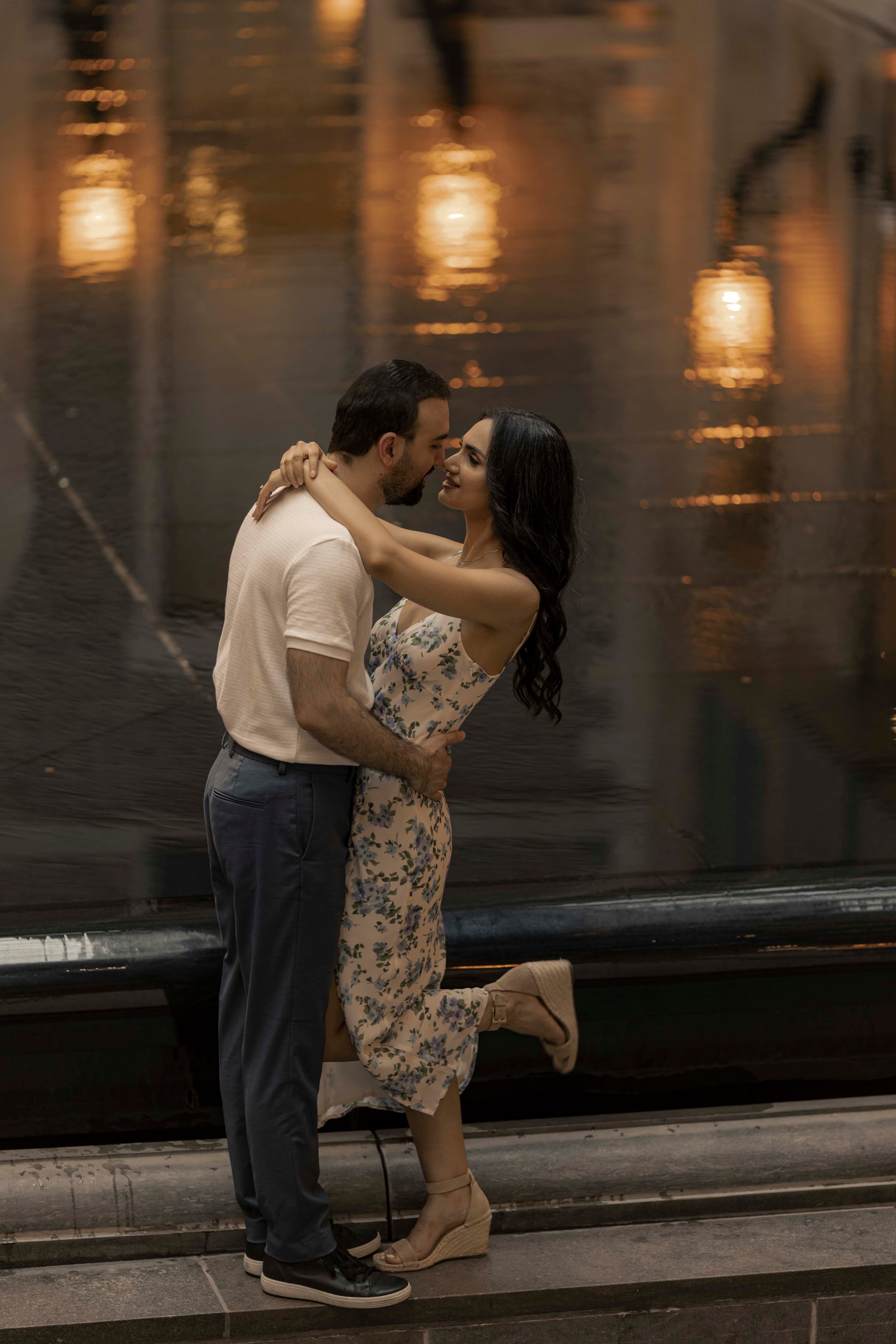 A couple embracing beneath a row of hanging lanterns