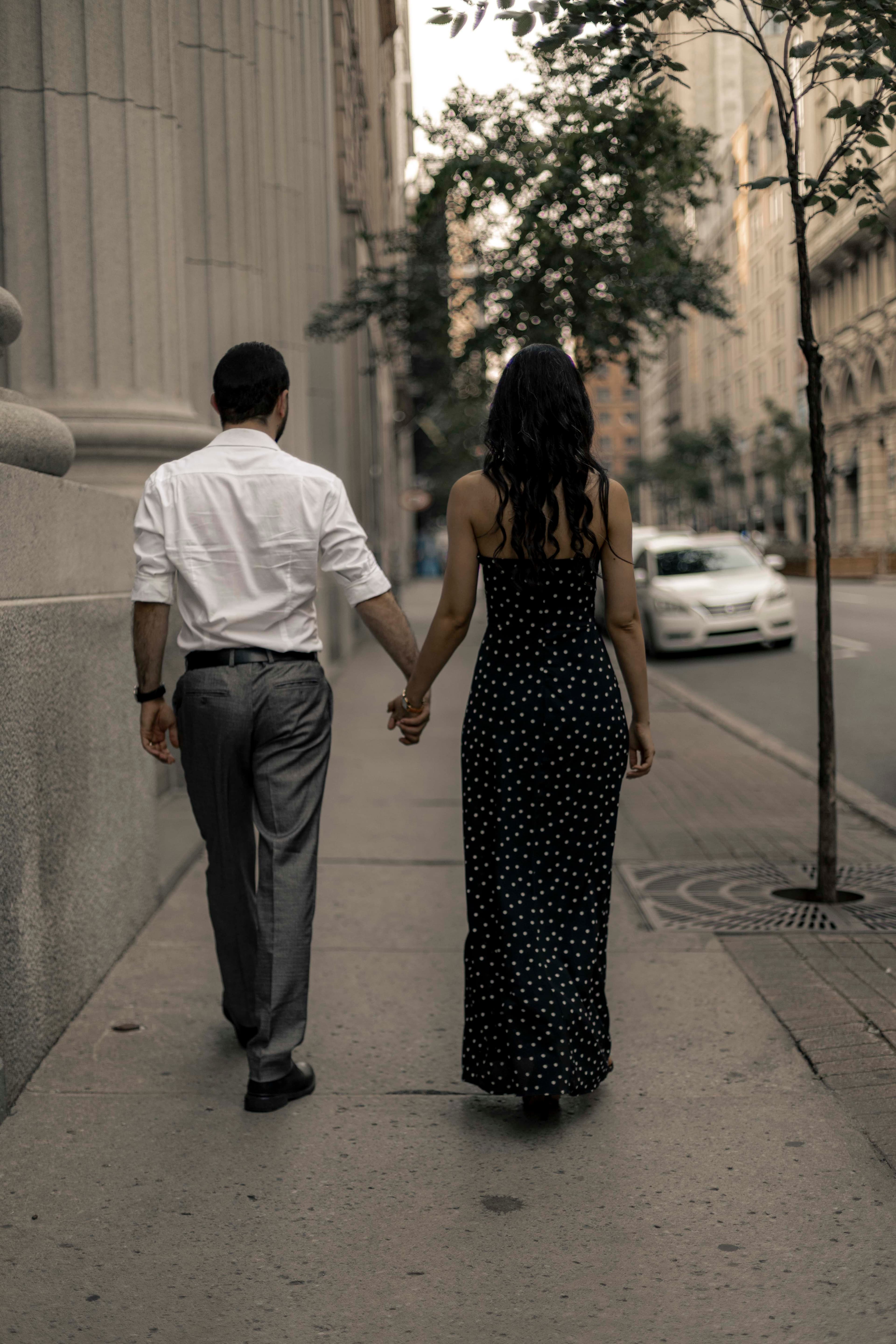 Hand in hand along a city street at dusk